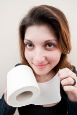 Woman holding hard toilet paper - hard toilet paper can cause hemorrhoids and scratch and abrade existing hemorrhoids.